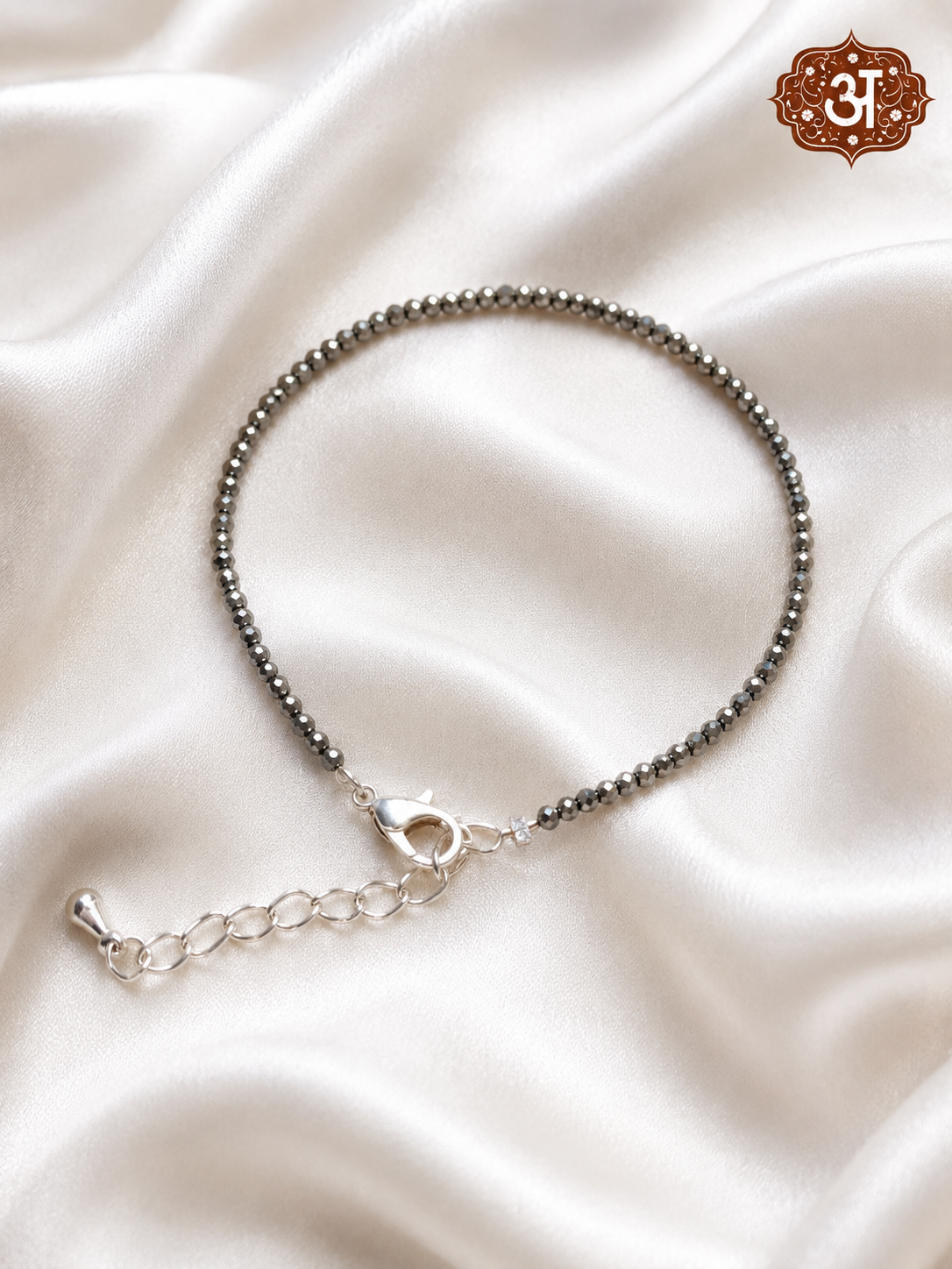 Silver bracelet on a soft beige fabric background